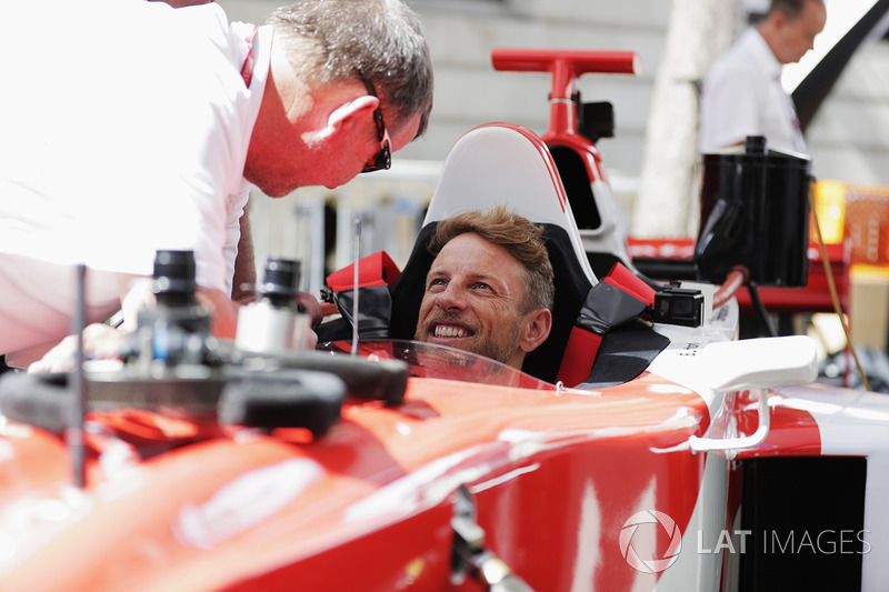 Jenson Button, McLaren, gets into the drivers seat of a 2 seat F1 demo car