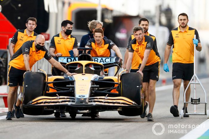 Los mecánicos empujan el coche de Daniel Ricciardo, McLaren MCL36, por el pitlane