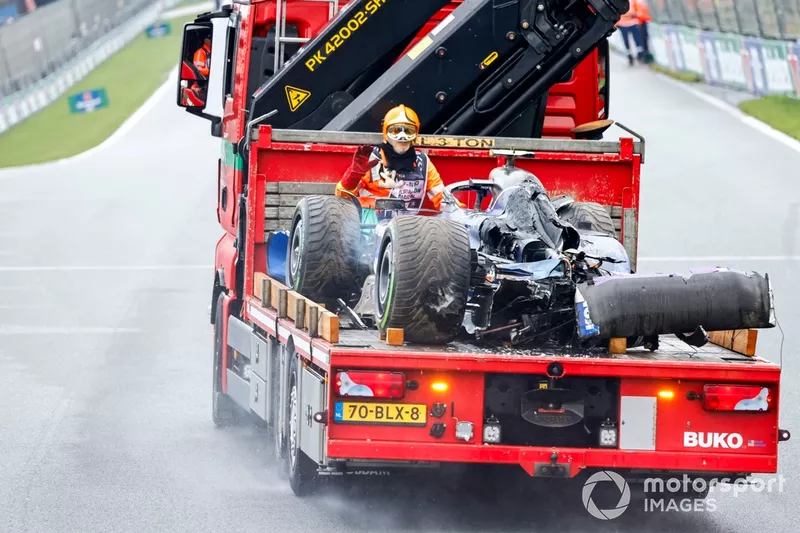 A marshal with the damaged car of Logan Sargeant, Williams FW46, on a truck