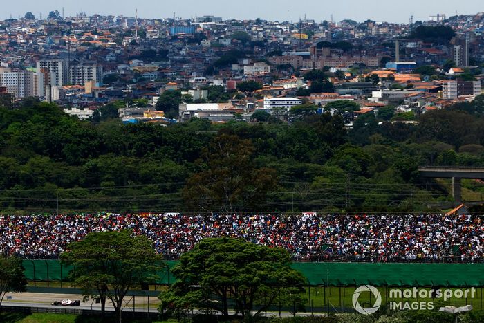 Mick Schumacher, Haas VF-22, pasa por una tribuna y la ciudad al fondo
