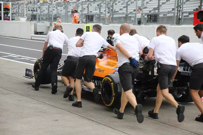 McLaren MCL34 siendo empujado por miembros del equipo