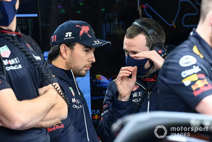 Sergio Perez, Red Bull Racing, conversa con un ingeniero en el garaje.