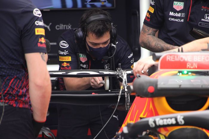 Miembros de Red Bull Racing revisan el alerón trasero del RB16B
