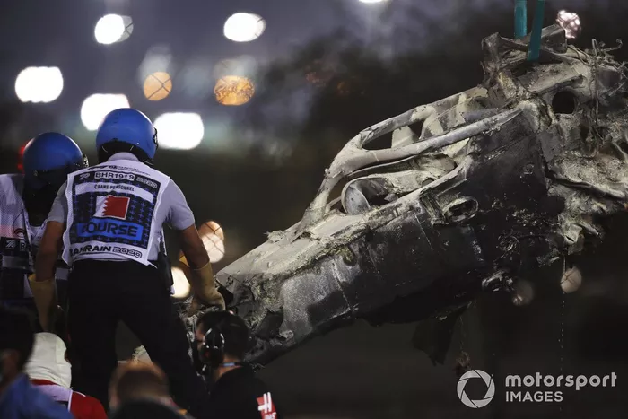 Los oficiales retiran los restos del monoplaza de Romain Grosjean, Haas VF-20, después del accidente en la primera vuelta