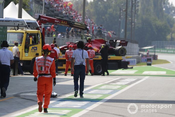 Los comisarios con el coche accidentado de Carlos Sainz Jr., Ferrari SF21