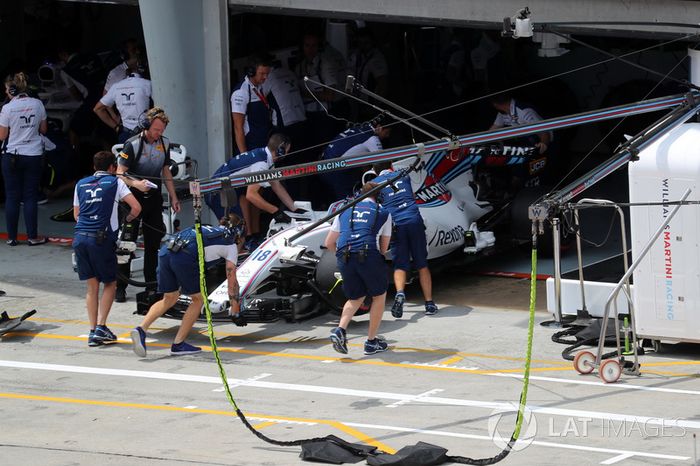 Mecánicos empujan el coche de Lance Stroll al garaje