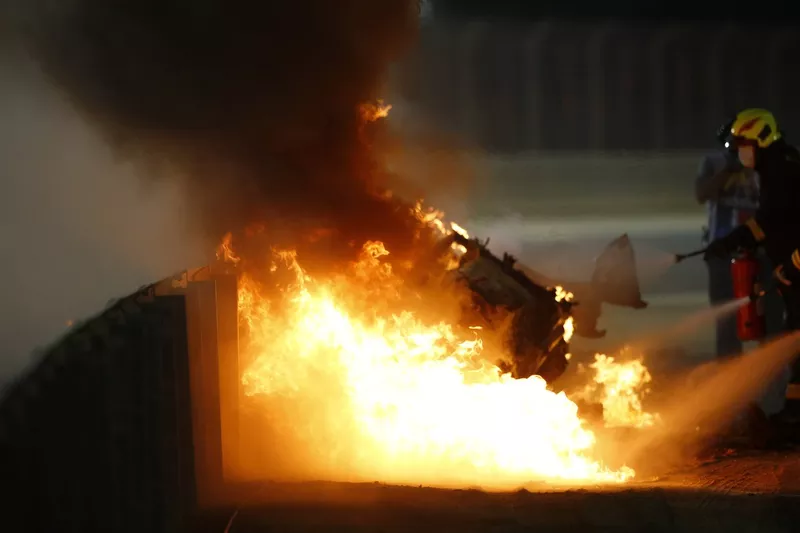 Marshals extinguish the flames after a big crash for Romain Grosjean, Haas VF-20, on the opening lap