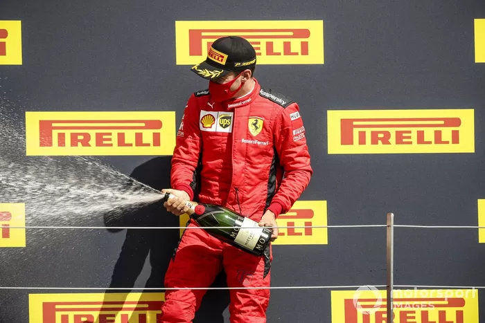 Charles Leclerc, Ferrari, terzo posto, festeggia sul podio con lo champagne