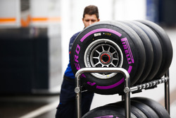 Un membro di un team attraversa il paddock con degli pneumatici Pirelli