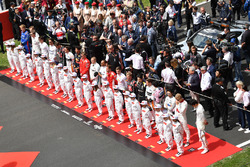 Drivers observe the National Anthem on the grid