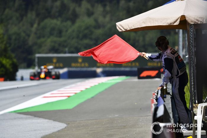 Un comisario con bandera roja al paso de Max Verstappen, Red Bull Racing RB16 