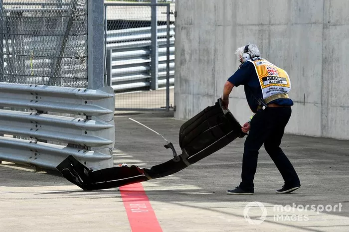 Un oficial de pista retira el alerón delantero de Romain Grosjean, Haas F1 Team VF-19