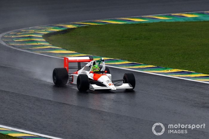 Lewis Hamilton conduce el McLaren MP4/5B mientras sigue la bandera brasileña desde el cockpit