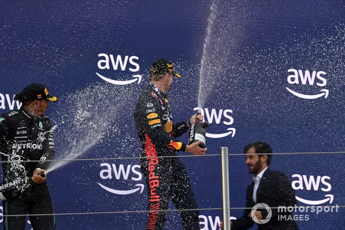 Lewis Hamilton, Mercedes-AMG, 2ª posición, Max Verstappen, Red Bull Racing, 1ª posición, George Russell, Mercedes-AMG, 3ª posición, spray de Champagne en el podio.