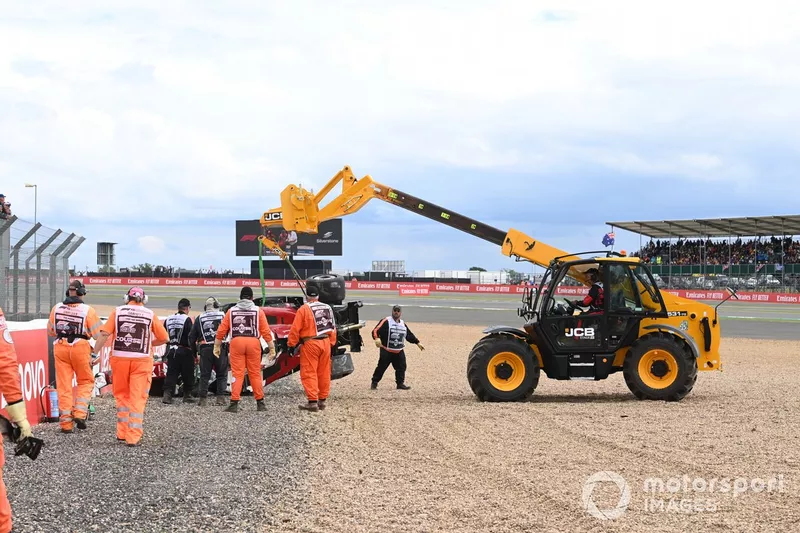 Los oficiales de pista retiran el coche dañado de Zhou Guanyu, Alfa Romeo C42