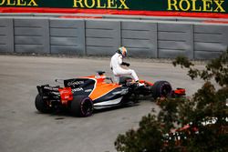 Fernando Alonso, McLaren, extracts himself from a leaking car in FP1