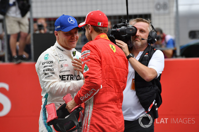 Il poleman Valtteri Bottas, Mercedes-AMG F1 e il terzo qualificato Sebastian Vettel, Ferrari, festeggiano nel parco chiuso