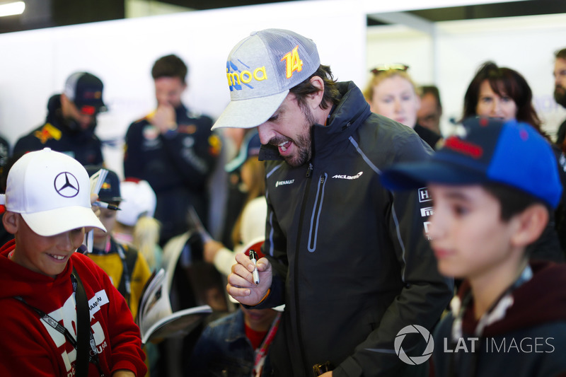 Fernando Alonso, McLaren, signs autographs for children