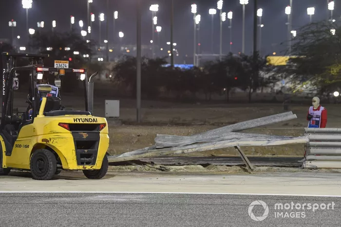 Los oficiales retiran los restos después del choque de Romain Grosjean, Haas VF-20, en la primera vuelta