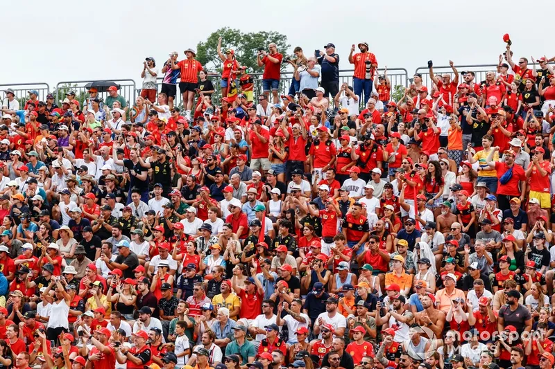 Une tribune remplie de fans de Ferrari acclame Leclerc qui prend la tête de la course.