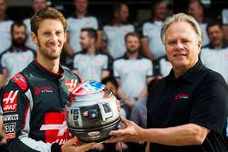 Romain Grosjean presents team owner Gene Haas with his commemorative helmet for the United States Grand Prix