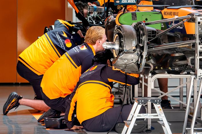McLaren mechanics work on the car 