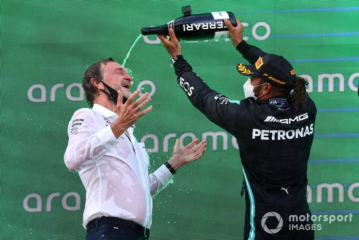 Lewis Hamilton, Mercedes, primera posición, derrama champán a su compañero de equipo en el podio