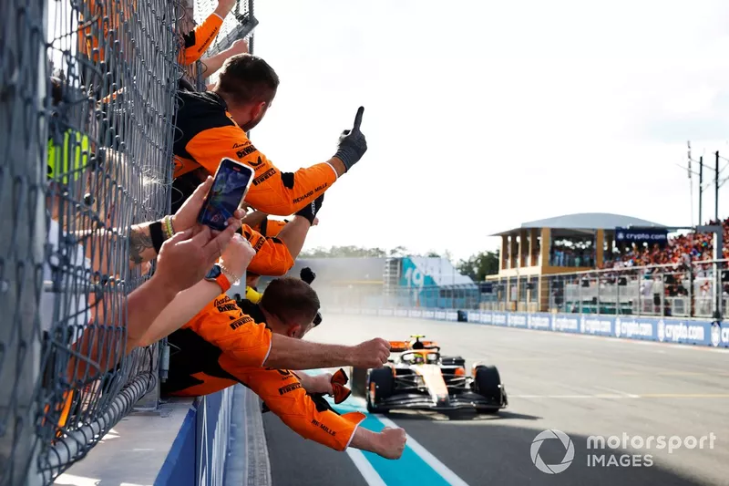 Lando Norris, McLaren MCL38, 1ère position, franchit la ligne sous les acclamations de son équipe sur le muret des stands.