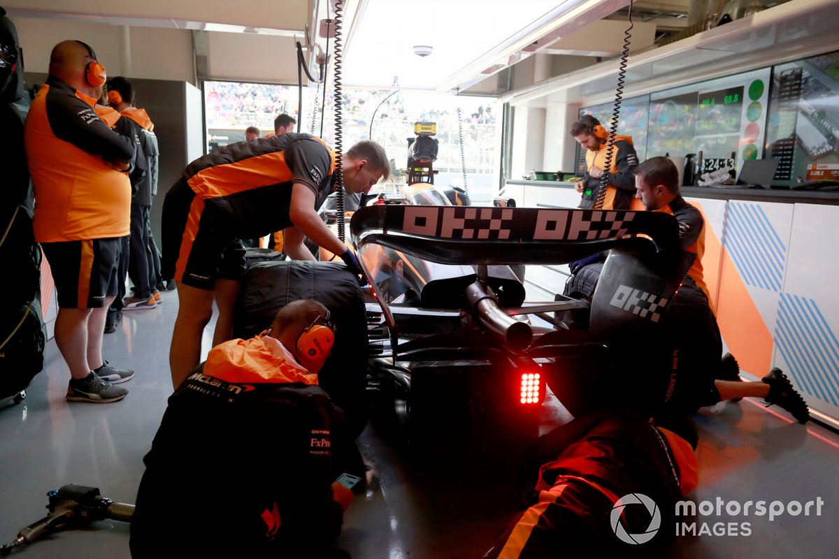 Mechanics work on the car of Lando Norris, McLaren MCL36, in the garage