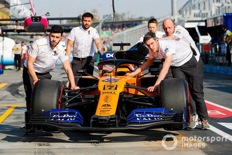 Mecánicos mueven el coche de Carlos Sainz Jr., McLaren MCL34