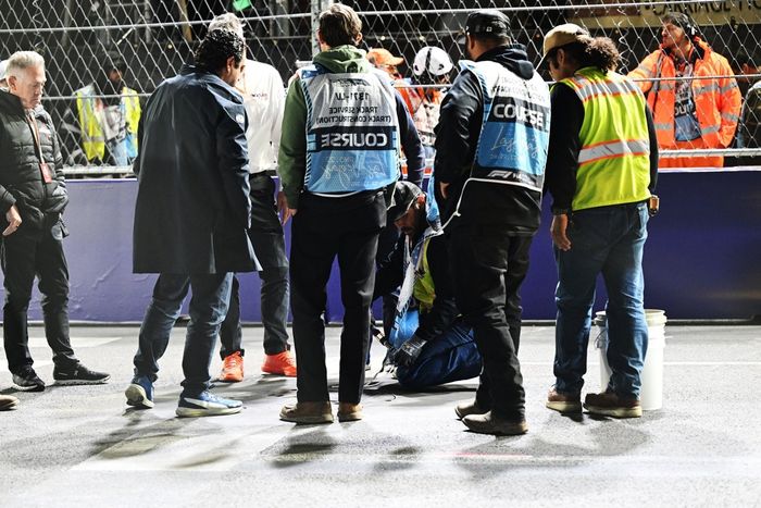 Los comisarios y el personal del circuito se reúnen para reparar una tapa de desagüe en la pista que provocó una bandera roja