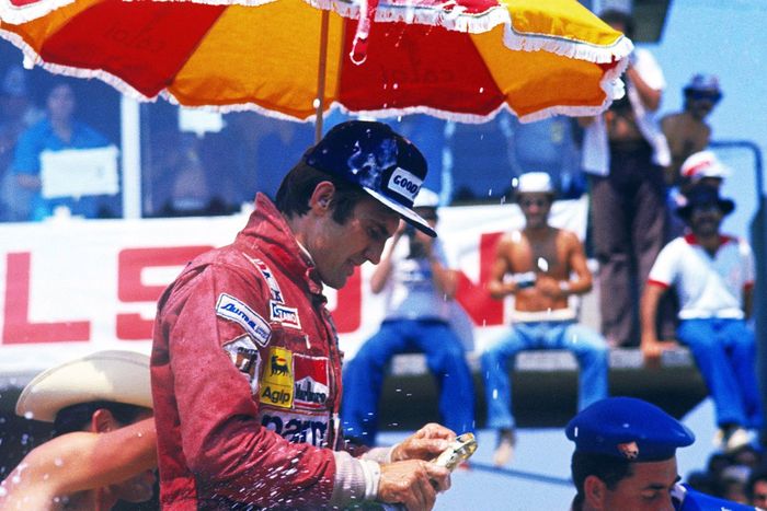 Carlos Reutemann, Ferrari celebra su victoria en el podio intentando abrir su botella de champán