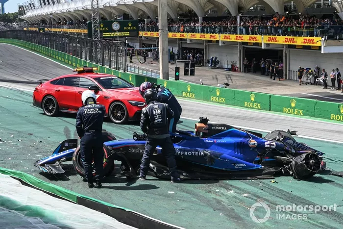 Delegados médicos de la FIA asisten a Alex Albon, Williams FW45, tras un choque en la salida con Kevin Magnussen, Haas VF-23