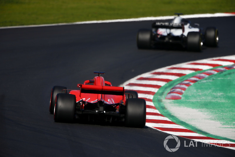 Romain Grosjean, Haas F1 Team VF-18, leads Kimi Raikkonen, Ferrari SF71H