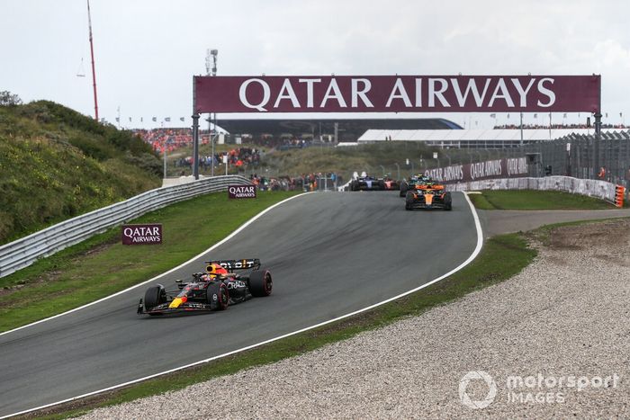 Max Verstappen, Red Bull Racing RB19, lidera Lando Norris, McLaren MCL60, Fernando Alonso, Aston Martin AMR23, y el resto de la parrilla en la primera vuelta.