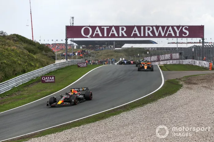 Max Verstappen, Red Bull Racing RB19, lidera Lando Norris, McLaren MCL60, Fernando Alonso, Aston Martin AMR23, y el resto de la parrilla en la primera vuelta.