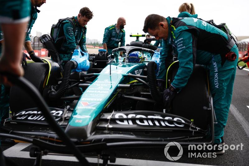 I meccanici di Aston Martin spingono l'auto di Fernando Alonso, l'Aston Martin AMR24, verso il suo posto sulla griglia di partenza.