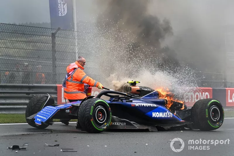 A marshal uses a fire extinguisher on the car of Logan Sargeant, Williams FW46, after a crash in FP3