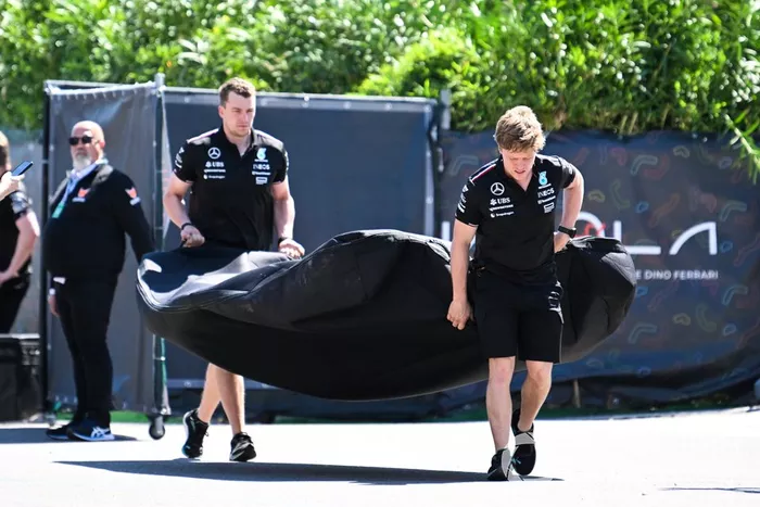 Les membres de l'équipe Mercedes-AMG F1 Team font rouler leur équipement dans le paddock.