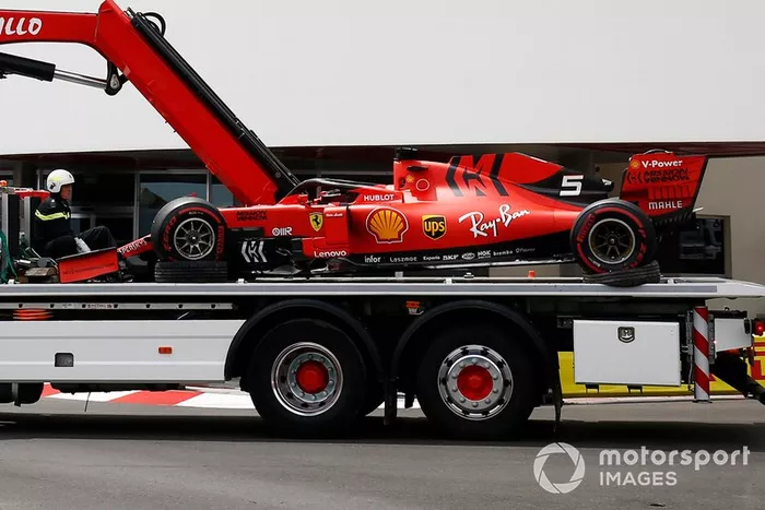 Una grúa devuelve al accidentado coche de Sebastian Vettel Ferrari SF90 al carril de boxes después del FP3