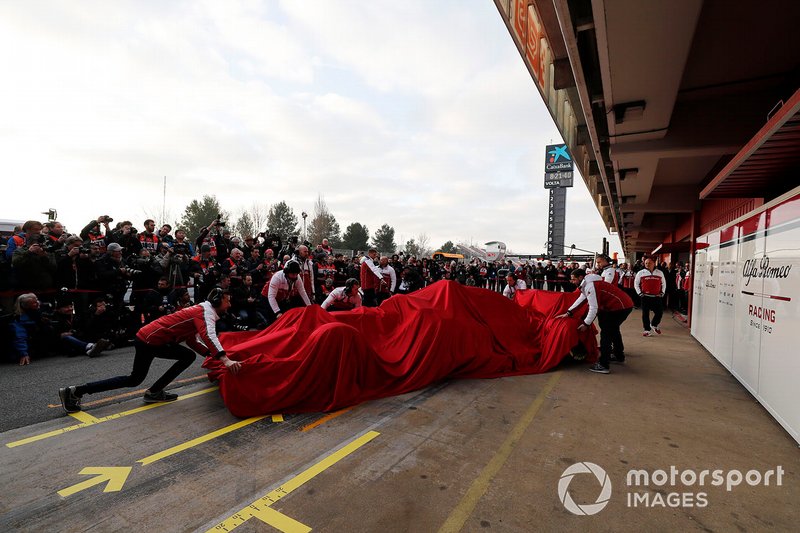 Alfa Romeo Racing mechanics with the Alfa Romeo Racing C38 under covers