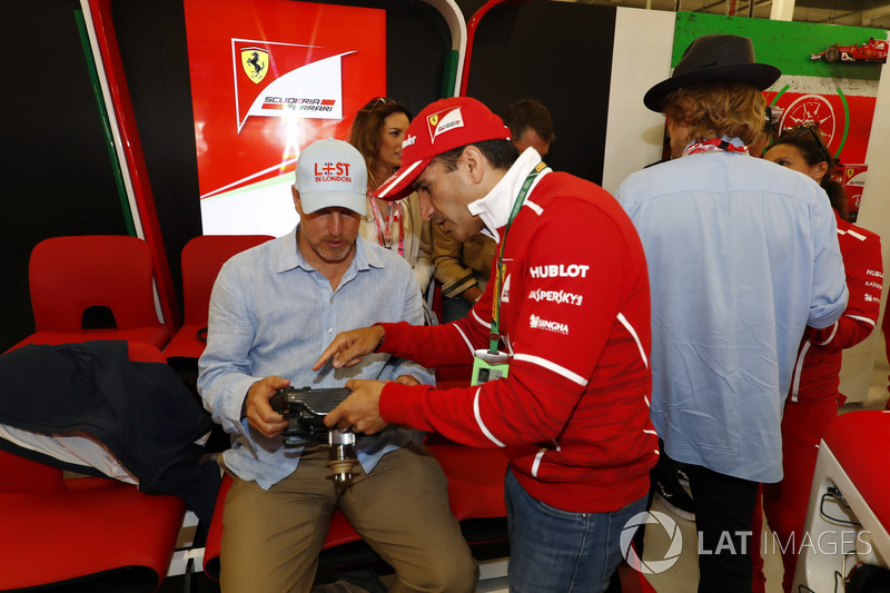 Marc Gene explica al actor Woody Harrelson las funciones de un volante de Ferrari, mientras Owen Wilson habla con un miembro del equipo Ferrari