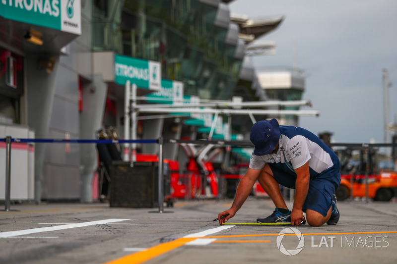 Williams mechanic marks out the pit box