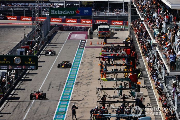 Carlos Sainz, Ferrari SF-23 y Sergio Pérez, Red Bull Racing RB19 en el pit lane tras una parada en boxes.