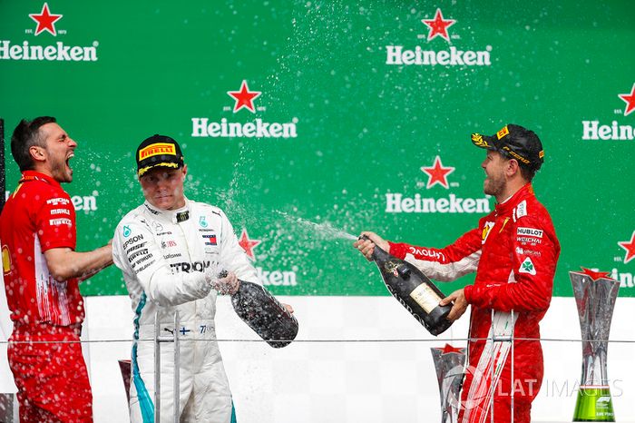 Valtteri Bottas, Mercedes AMG F1, y Sebastian Vettel, Ferrari, celebran en el podio