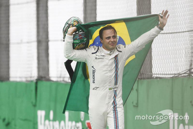 Felipe Massa, Williams, carries a Brazilian flag as he walks back to his garage in tears after crashing