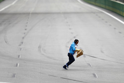 A marshal collects debris from the track