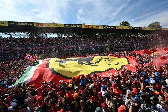 Supporters and Ferrari fans deploy a giant Ferrari flag on the track.
