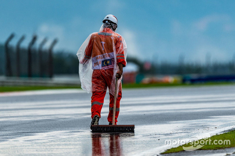 Un commissaire évacue l'eau de la piste