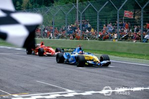 El ganador de la carrera Fernando Alonso, Renault R25, toma la bandera a cuadros, seguido por Michael Schumacher, Ferrari F2005